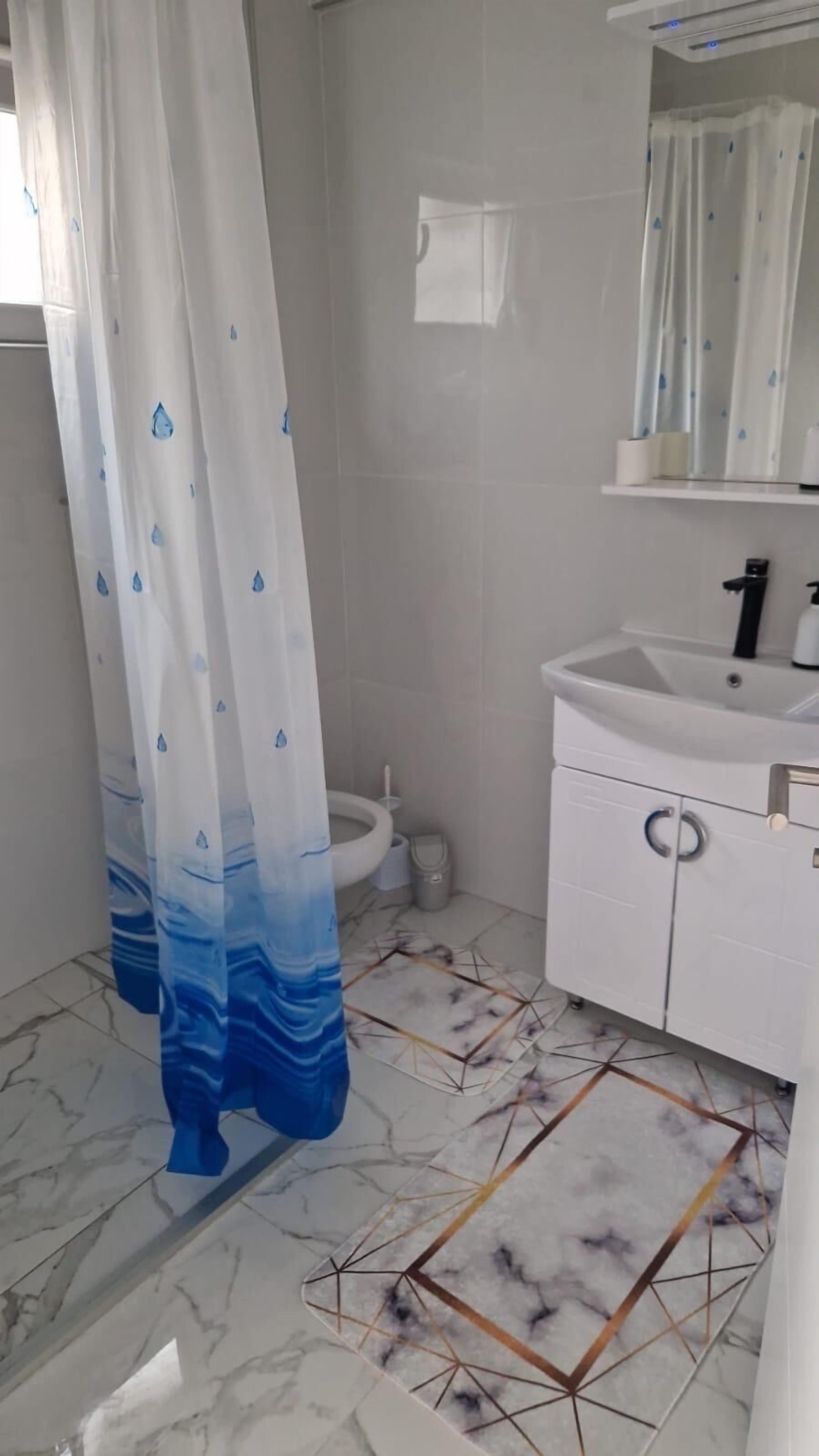 Un baño con inodoro, lavabo y espejo.