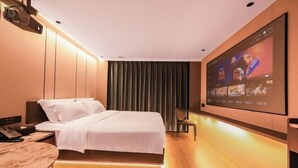 Ein modernes Hotelzimmer mit Bett, Nachttisch, Fernseher und einem großen Fenster mit Vorhängen.