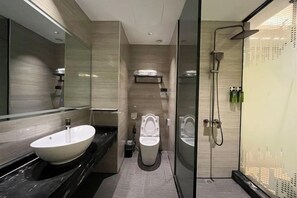 Ein modernes Badezimmer mit einem großen Spiegel, zwei Waschbecken, einer Toilette und einer Duschkabine.