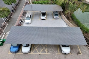 Un área de estacionamiento con espacios cubiertos y un pasillo techado.