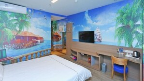 Une chambre d’hôtel comprenant un lit, un bureau avec une chaise, une télévision et une fresque murale représentant un paysage de plage tropicale.