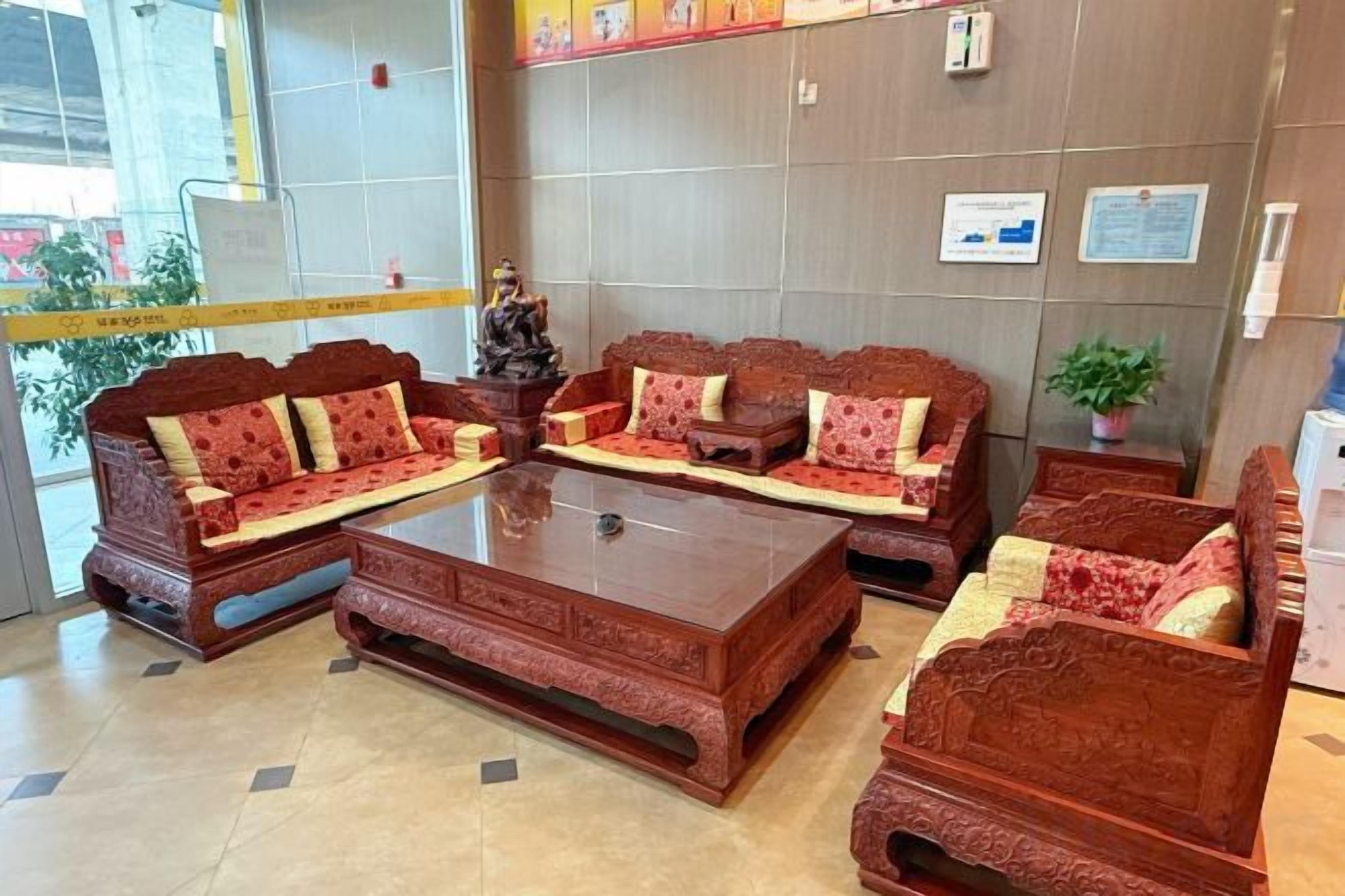 A reception area with a sofa set, a coffee table, and a potted plant.