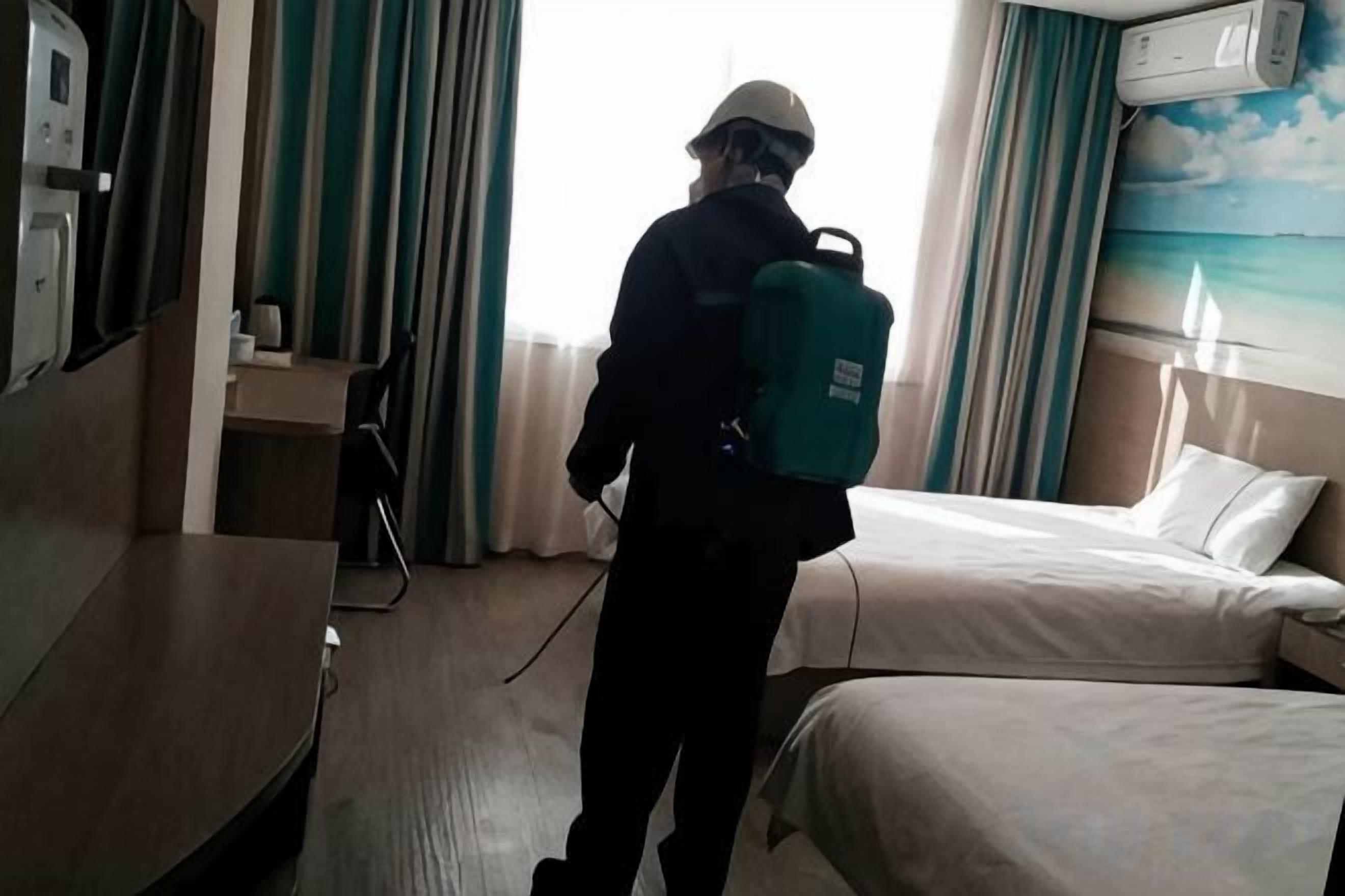Une chambre d’hôtel avec un lit, un bureau et une fenêtre avec des rideaux.