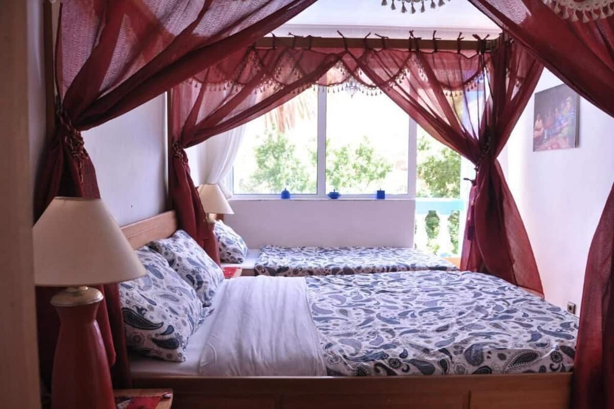 Habitación triple familiar, vista al jardín | Área de sala de estar