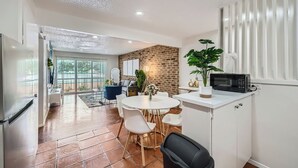 A modern kitchen with a white countertop, a black microwave, and a potted plant. - 2B Getaway | Steps 2 Dtwn | Sleeps 6 | Pool + Prkg (Austin)