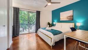 A bedroom with a bed, a desk, a ceiling fan, and a view of greenery through the window. - 2B Getaway | Steps 2 Dtwn | Sleeps 6 | Pool + Prkg (Austin)