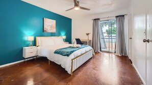 A bedroom with a bed, bedside tables, a ceiling fan, and a view through a window with curtains. - 2B Getaway | Steps 2 Dtwn | Sleeps 6 | Pool + Prkg (Austin)