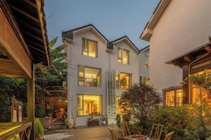 A two-story building with a covered outdoor area and a staircase leading to the upper floor.