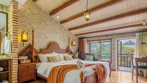 Une chambre à coucher avec un lit en bois, une table de chevet, une lampe et une vue sur l’extérieur.