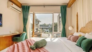 Une chambre d’hôtel avec un lit, un bureau et une vue sur la ville.