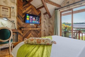 A room with a bed, a mounted TV, a wooden ceiling, and a balcony with a view. - Hangzhou William Toffee Hotel (Zhejiang University) (Hangzhou)
