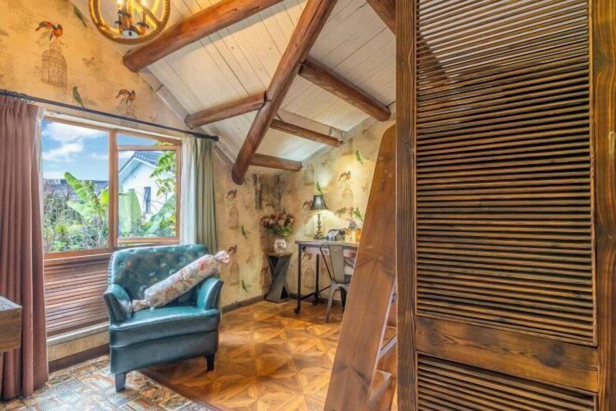 Une pièce avec un plafond en bois, un parquet à motifs, un canapé, une table avec une lampe et une fenêtre avec des rideaux.