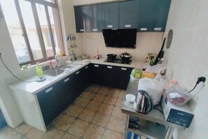 A compact kitchen with a sink, stove, and cabinets. - Shengsi Leju Xiaozhuang (Shengsi)