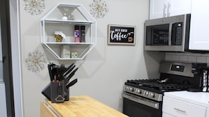 A modern kitchen with a wooden countertop, white cabinets, a stove, and a microwave. - Brand new 2-bedroom in charming Santa Maria with WiFi, AC (Santa Maria)
