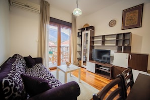 Relax in a spacious living room with a sofa set, flat-screen TV, and dining area.