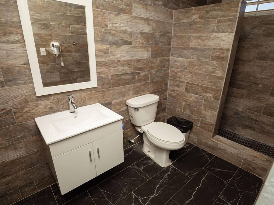 A bathroom with a white sink, toilet, and shower area.