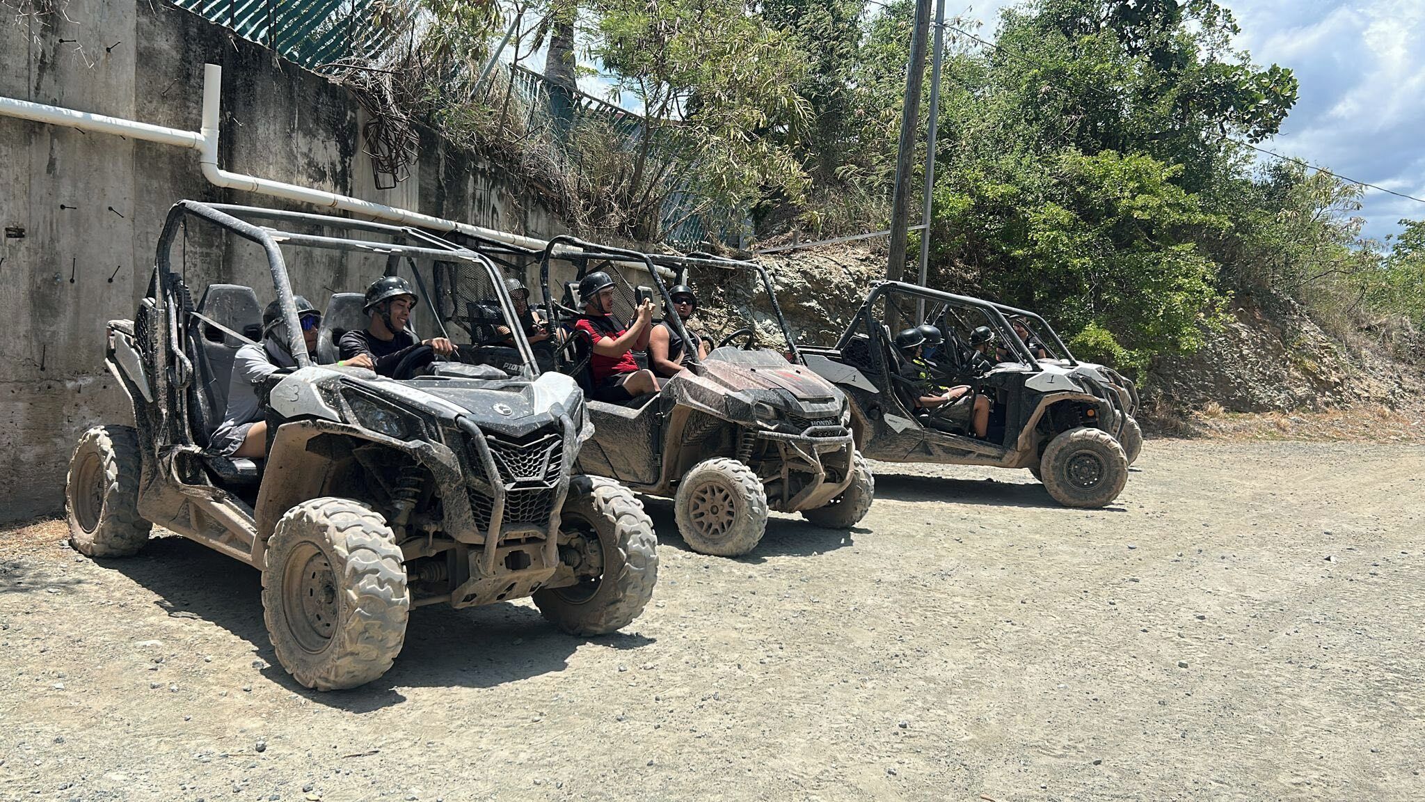 Three off-road vehicles parked on a dirt road.