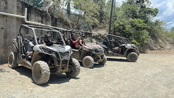 Three off-road vehicles parked on a dirt road.