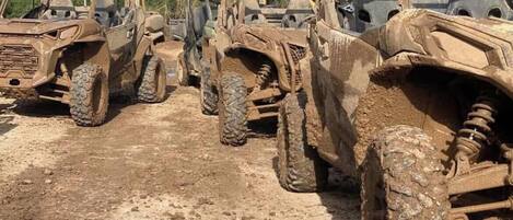 A row of off-road vehicles parked outdoors.