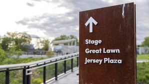 Señal direccional para Stage Great Lawn Jersey Plaza con flecha hacia arriba.