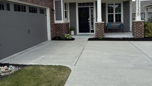 Una casa de dos pisos con garaje, un porche delantero y un césped bien cuidado.