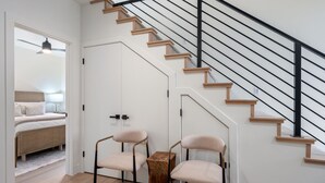 A modern interior with a staircase, a bed, and two chairs. - Charming 2-bedroom house Near Zion & Sand Hollow (HURRICANE)
