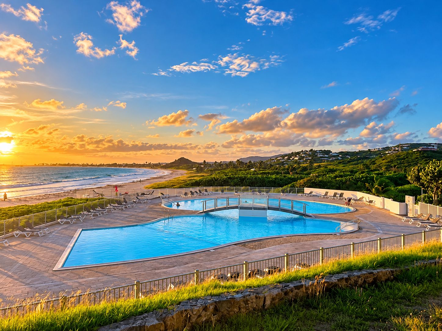 Ein Poolbereich mit Blick auf den Strand und den Sonnenuntergang.