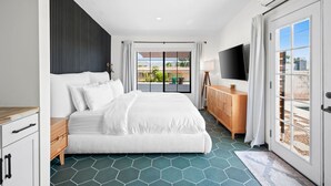 Une chambre d’hôtel moderne avec un grand lit, une commode en bois, une télévision et une vue sur l’extérieur.