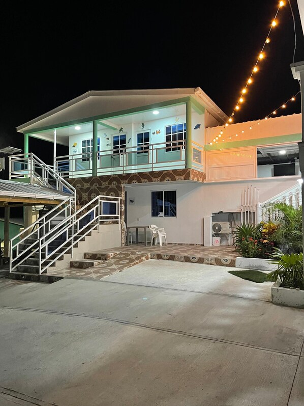 A two-story building with a balcony, a staircase, and a covered outdoor area. - Posada Three Cay Suites (Providencia)
