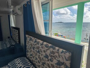 A room with a bed, a window with a view of the sea, and a sign reading "ROCKPOINT". - Posada Three Cay Suites (Providencia)