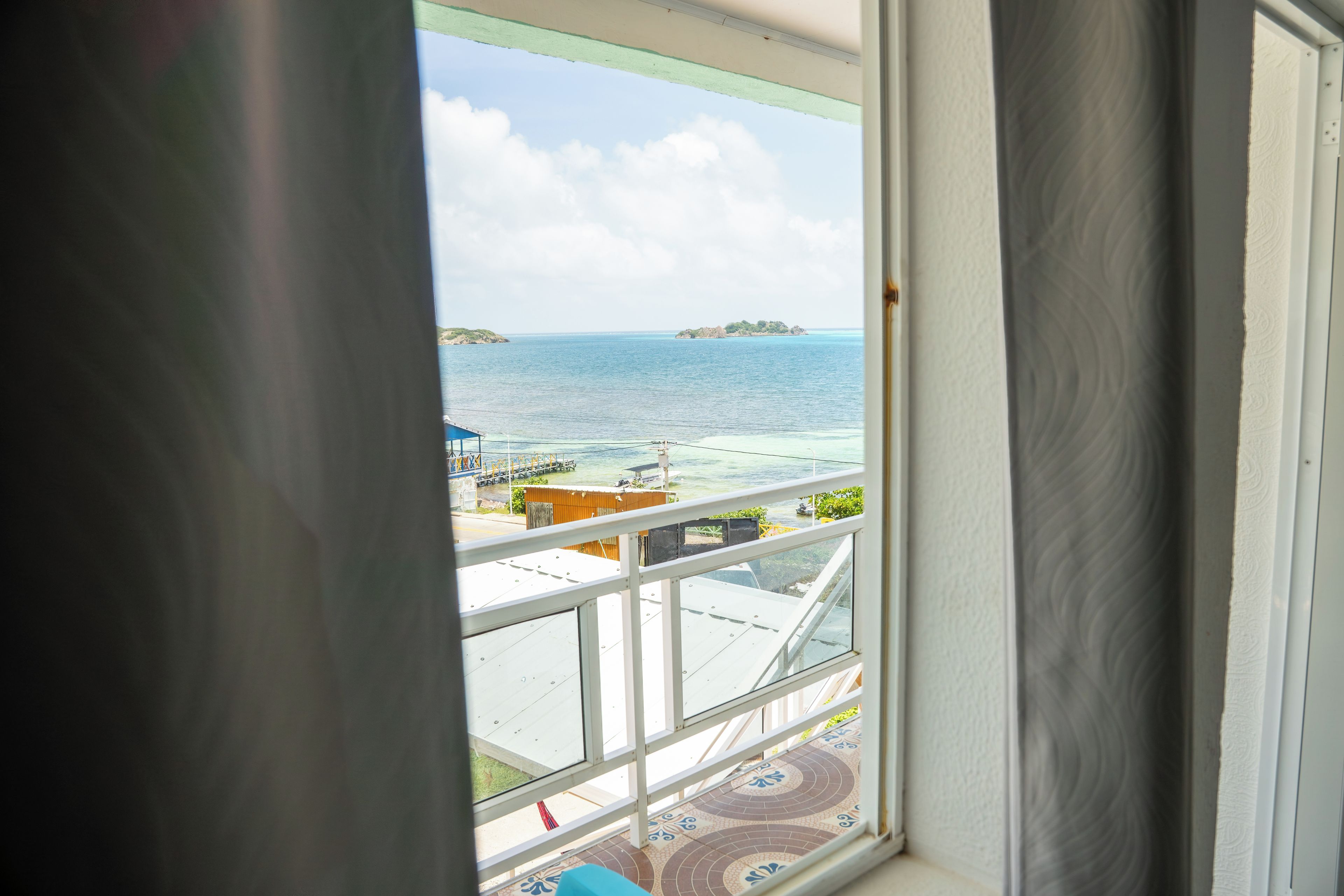 A view from a window overlooking a body of water with a small island in the distance.