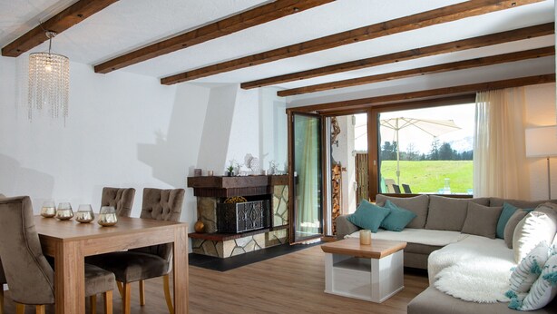 A living room with a wooden dining table, sofa, and fireplace.