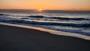 A beach with waves at sunset.