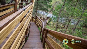 A wooden pedestrian bridge with railings, surrounded by dense forest and a river below. - Steps from Bryce Resort - Ski slope views & golf (Basye)