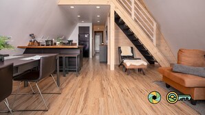 A modern loft-style living space with a kitchen, dining area, and a staircase leading to an upper level. - Steps from Bryce Resort - Ski slope views & golf (Basye)