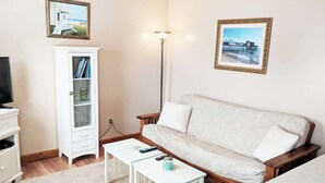 Een woonkamer met een bank, een kast, een salontafel en een vloerlamp.