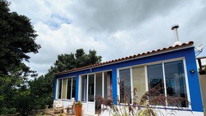 Een blauw huis met grote ramen en een schotelantenne.
