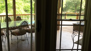 A wooden deck with a glass door leading to an outdoor seating area with metal chairs and a table. - Charming 3-bedroom house in lovely Rome with WiFi, AC (Rome)