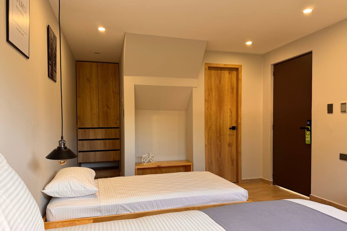 A modern bedroom with a bed, a wooden wardrobe, a nightstand, and a bicycle decoration.