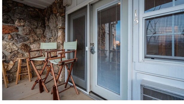 Un muro de piedra, una puerta y una ventana con el número 5.