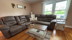Una sala de estar con un sofá modular, una mesa de centro y una mesita auxiliar.
