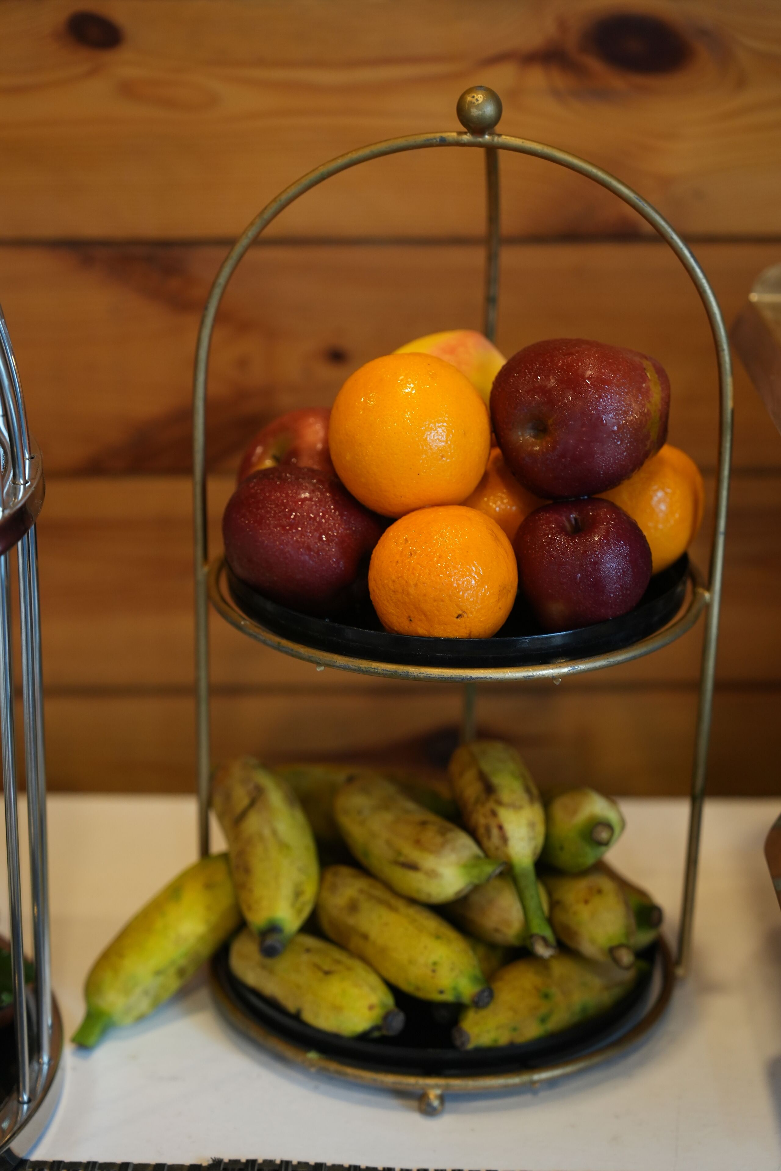 Un puesto de frutas con manzanas y naranjas en la parte superior y plátanos en la inferior.