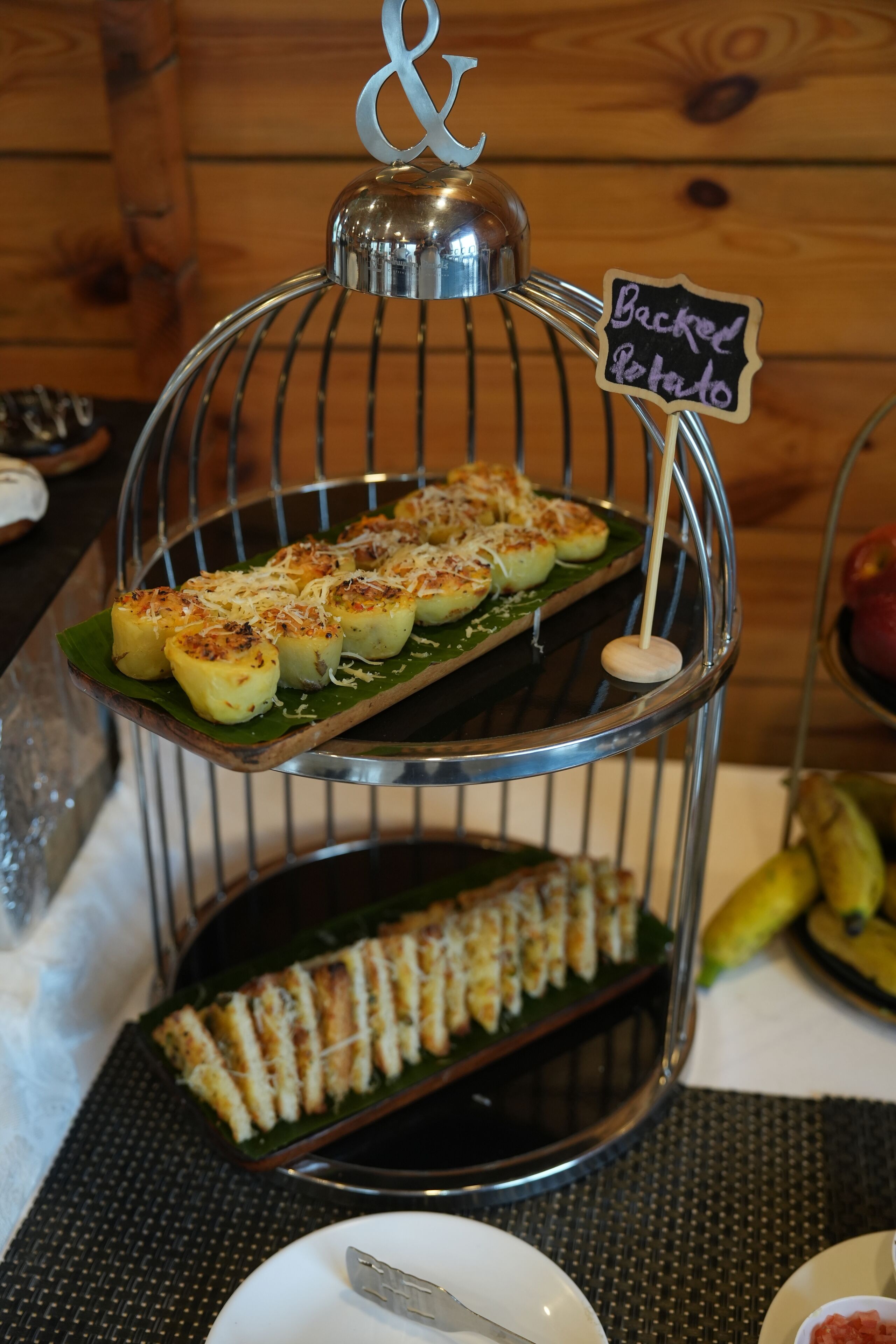 A dessert display with a sign indicating 'Backed Potato' on a metal stand.