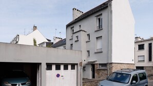 Ein Wohngebäude mit Garage, heller Fassade und Steinunterbau.