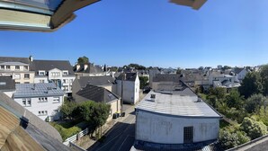 Ein Wohngebiet mit verschiedenen Gebäuden, darunter ein weißes Haus mit Runddach und einer Straße im Vordergrund.