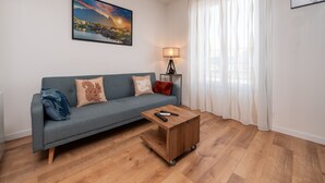 Ein Wohnzimmer mit einer Couch, einem Couchtisch, einer Lampe und einem Gemälde an der Wand.