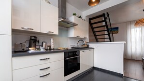 Eine moderne Küche mit weißen Schränken, einem schwarzen Backofen und einer Kaffeemaschine.