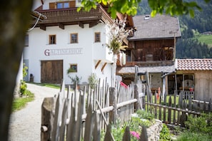 Un edificio tradicional con un letrero que dice 'GALTINERHOF' y una valla de madera al frente.