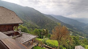 A wooden building with a sloped roof, a balcony, and a view of a valley with mountains. - Apartment 'Galtinerhof Almstadel' with Mountain View, Shared Terrace and Wi-Fi (Rodengo)