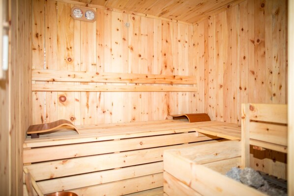 A wooden sauna with benches, a bench on the right, and a bench on the left.
